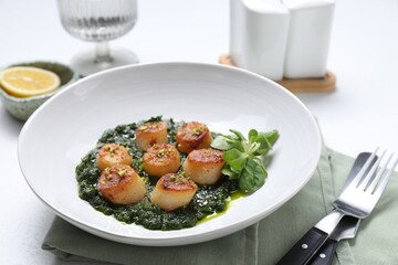 Delicious fried scallops with tasty sauce and corn salad in bowl on white table, closeup
