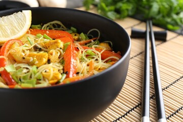 Stir-fry. Delicious cooked noodles with chicken and vegetables in bowl served on table, closeup