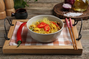 Stir-fry. Tasty noodles with vegetables and meat in bowl served on wooden table