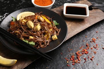 Stir-fry. Tasty noodles with vegetables and meat served on dark textured table
