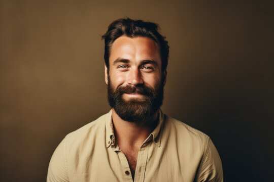 Portrait of a handsome man with a beard on a brown background