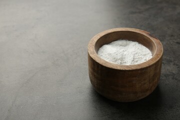 Baking powder in bowl on grey textured table, space for text