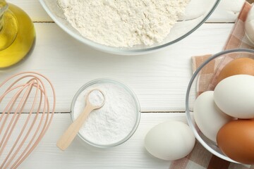 Flat lay composition with baking powder and eggs on white wooden table