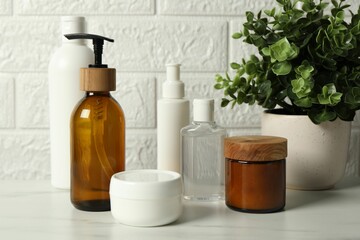 Bath accessories. Personal care products on white table near brick wall