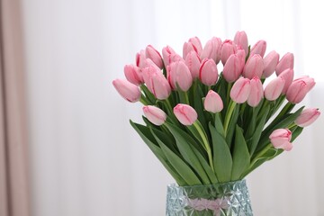 Bouquet of beautiful pink tulips in vase indoors, space for text