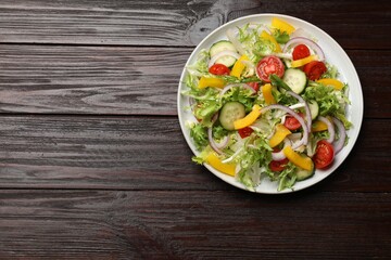 Tasty fresh vegetarian salad on dark wooden table, top view. Space for text