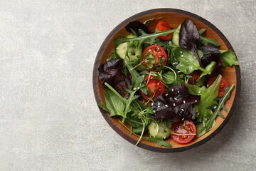 Tasty fresh vegetarian salad on grey table, top view. Space for text