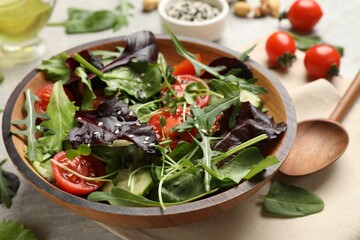 Tasty fresh vegetarian salad and ingredients on grey table, closeup