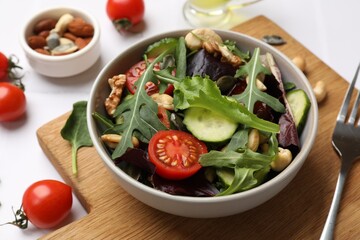 Tasty fresh vegetarian salad and ingredients on white table, closeup