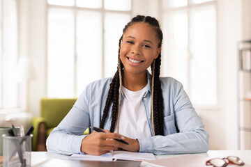 Confident black lady student smiling at camera, ready for e-learning