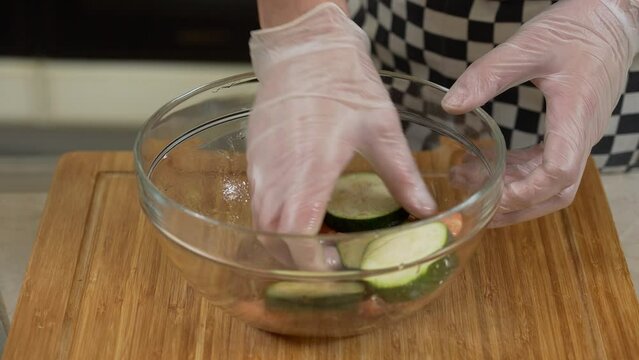 Chef is seasoning zucchini slices and shrimps while preparing caprese appetizer