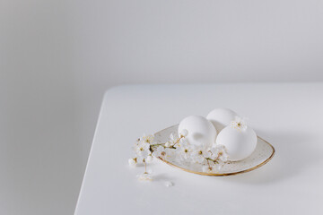 Beautiful branch with white blossom and eggs on a white background. Minimal concept.