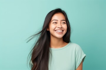 beauty, people and hair care concept - happy young asian woman with long hair over turquoise...