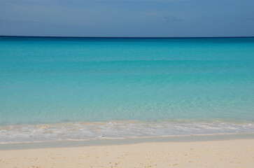 Tropical beach landscape, soft turquoise sea, clear sandy beach, blue sky