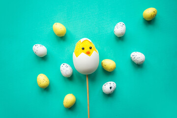 Toy chicken and quail eggs on bright background. Easter concept