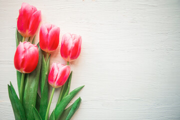 Pink tulips on wooden background. Flat lay, top view, copy space. Easter or Mother's Day greeting card