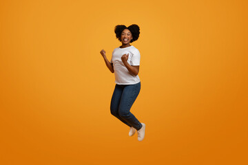 Fototapeta na wymiar Excited young african american lady jumping in the air