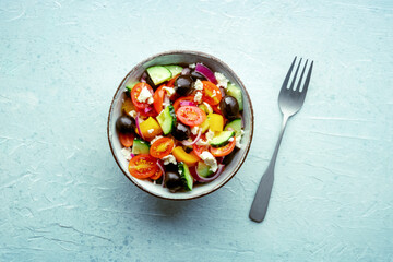Greek salad. Fresh tomato, cucumber, bell pepper, Feta cheese, onion, and olives. Healthy summer food, overhead flat lay shot, with a fork - 752171982