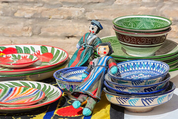 Fototapeta na wymiar Multicolored uzbek porcelain and gift puppet. Street market display. Khiva, Uzbekistan
