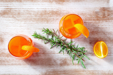 Orange cocktails with rosemary, overhead flat lay shot on a wooden background - 752172912