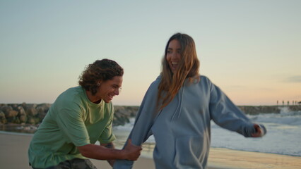 Carefree lovers having fun at sunset beach. Love couple embracing at sea coast