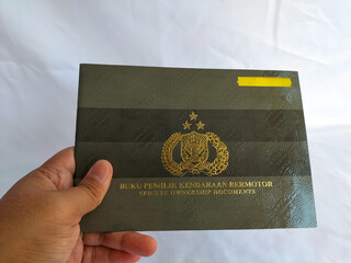 Close-up view of vehicle ownership book or Buku Pemilik Kendaraan Bermotor (BPKB) on white background. Book of the legal owner of a motor vehicle. 