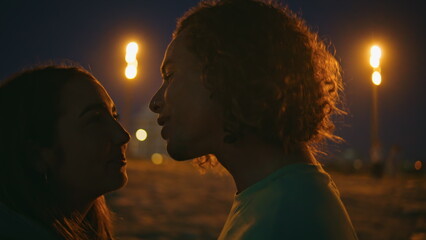 Affectionate teenagers talking evening shoreline close up. Man kissing love girl