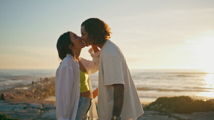 Ocean kiss teenagers couple sunset. Happy pair romantic date at marine evening