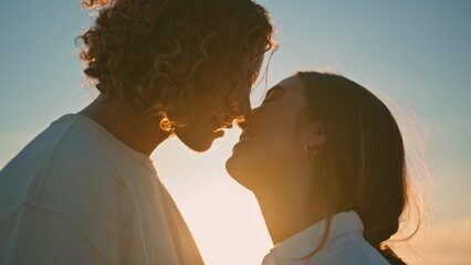 Young pair kiss at sunset ocean coast close up. Happy couple romantic evening