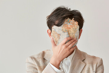 Man Holding Map in Front of Face on Neutral Background