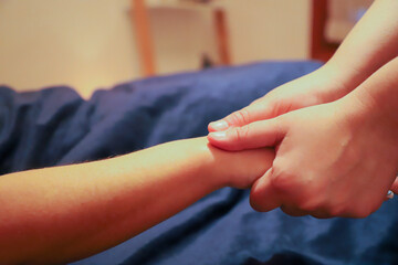 Masseur providing a hand massage to a client.