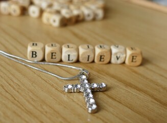 Believe - wooden letters and cross religion background