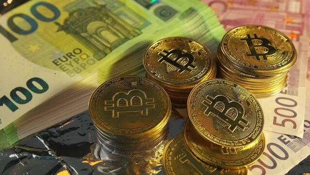 Bitcoin coins BTS Bit-coin cryptocurrency on euro bills various value. Blockchain technology. Rotating money background.