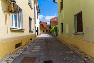 Diminishing view of alley at the old town of Slovenian City of Kranj on a sunny summer day. Photo taken August 10th, 2023, Kranj, Slovenia.