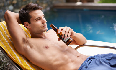 Man, bed and drink by swimming pool with beer to relax or chill on summer vacation, luxury and...