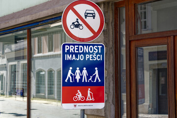Old town of Slovenian City of Kranj with traffic signs and text pedestrians priority on a sunny day. Photo taken August 10th, 2023, Kranj, Slovenia.