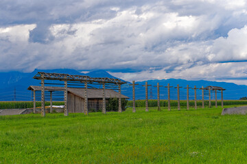 Wrecked hayrack with wooden barn at farmland at village of Zabnica on a blue cloudy summer evening....