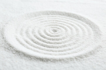 Fototapeta na wymiar Zen rock garden. Circle pattern on white sand, closeup