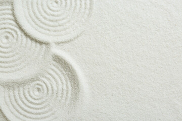 Fototapeta na wymiar Zen rock garden. Circle patterns on white sand, top view. Space for text