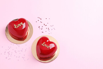 Obraz na płótnie Canvas St. Valentine's Day. Delicious heart shaped cakes on light pink background, flat lay. Space for text