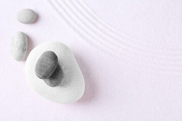 Fototapeta na wymiar Zen garden stones on white sand with pattern, flat lay. Space for text