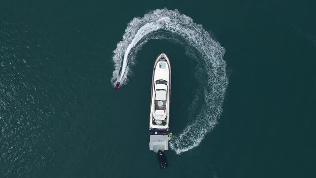 Yacht sailing on open sea luxury yacht in the circle and making beautiful shapes in the clear ocean. Hot summer day, enjoying water sport. Luxury holiday Motor boat sailing blue sea. Aerial view of lu