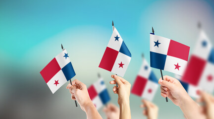 A group of people are holding small flags of Panama in their hands.