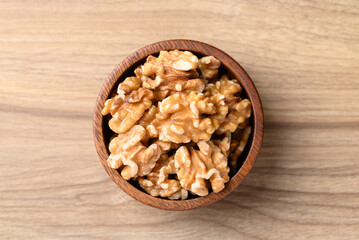 Organic raw walnuts in wooden bowl, Food ingredient, top view