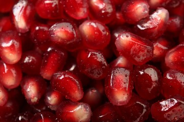 Ripe juicy pomegranate grains with water drops as background, top view