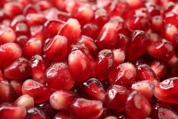 Ripe juicy pomegranate grains with water drops as background, closeup
