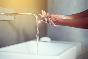 Hands, water and soap for cleaning with person in bathroom, hygiene and wellness for protection...
