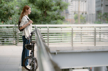 Eco friendly, businesswoman ride bicycle in urban to reduce carbon footprint. Beautiful woman environment preservation person commuting with bicycling. Cycling, alternative transport for clean energy.