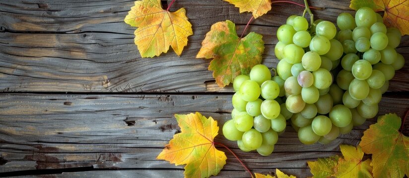 A cluster of green grapes sits on top of a wooden table in a simple yet elegant display.