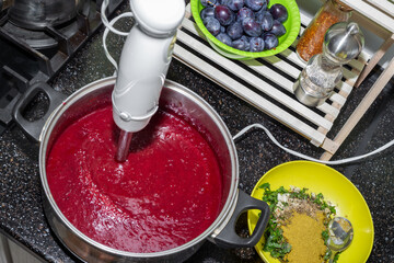A pan with plum puree whipped with a blender and seasonings for making tkemali sauce, top view